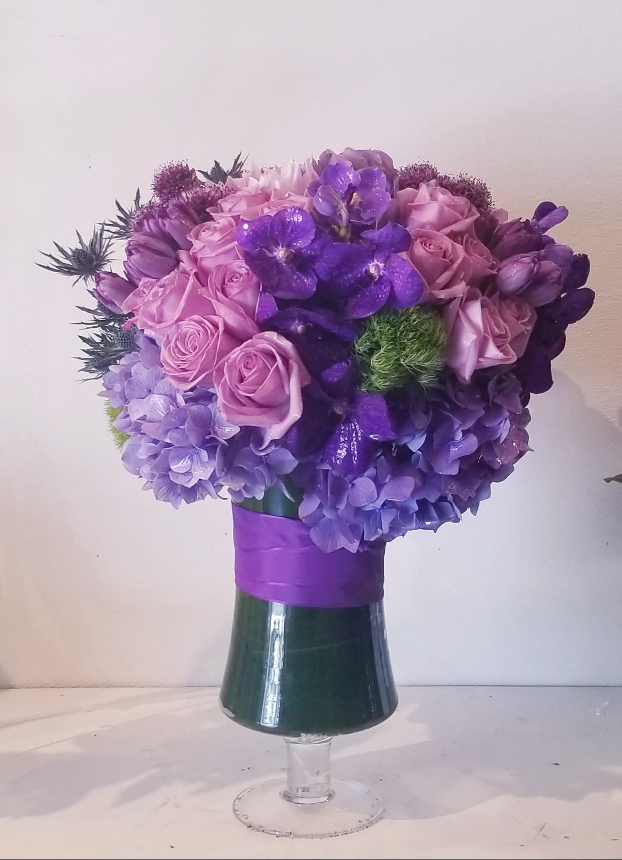 Violeta - A composition of purple color blooms designed in tall urn.