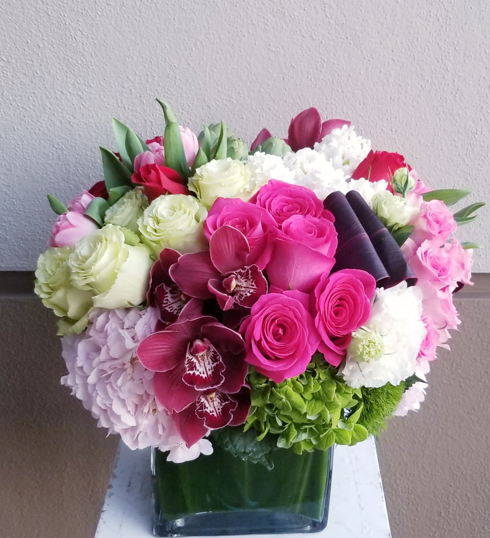 So Sweet - Low square composed of mostly pink and a touch of white and green blooms. Perfect for any occasion.