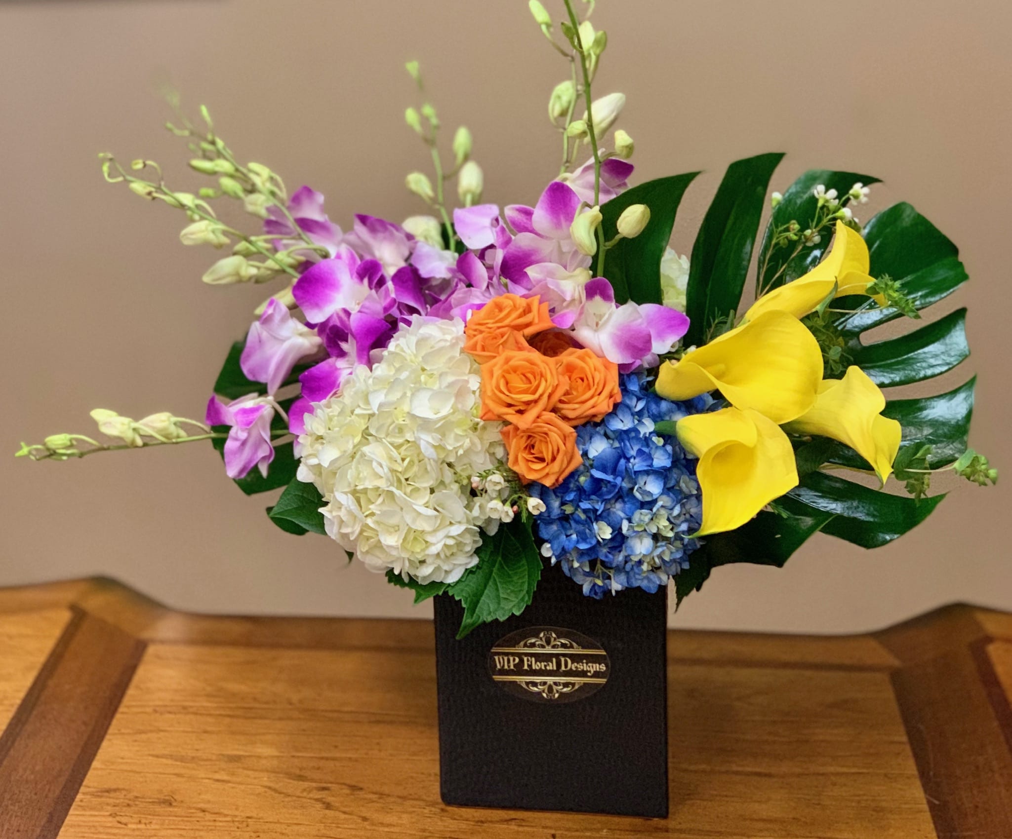 Simply Gorgeous Simply Gorgeous - Dendrobium orchids, mini calla lilies, hydrangeas, spray roses, tropical leaves.