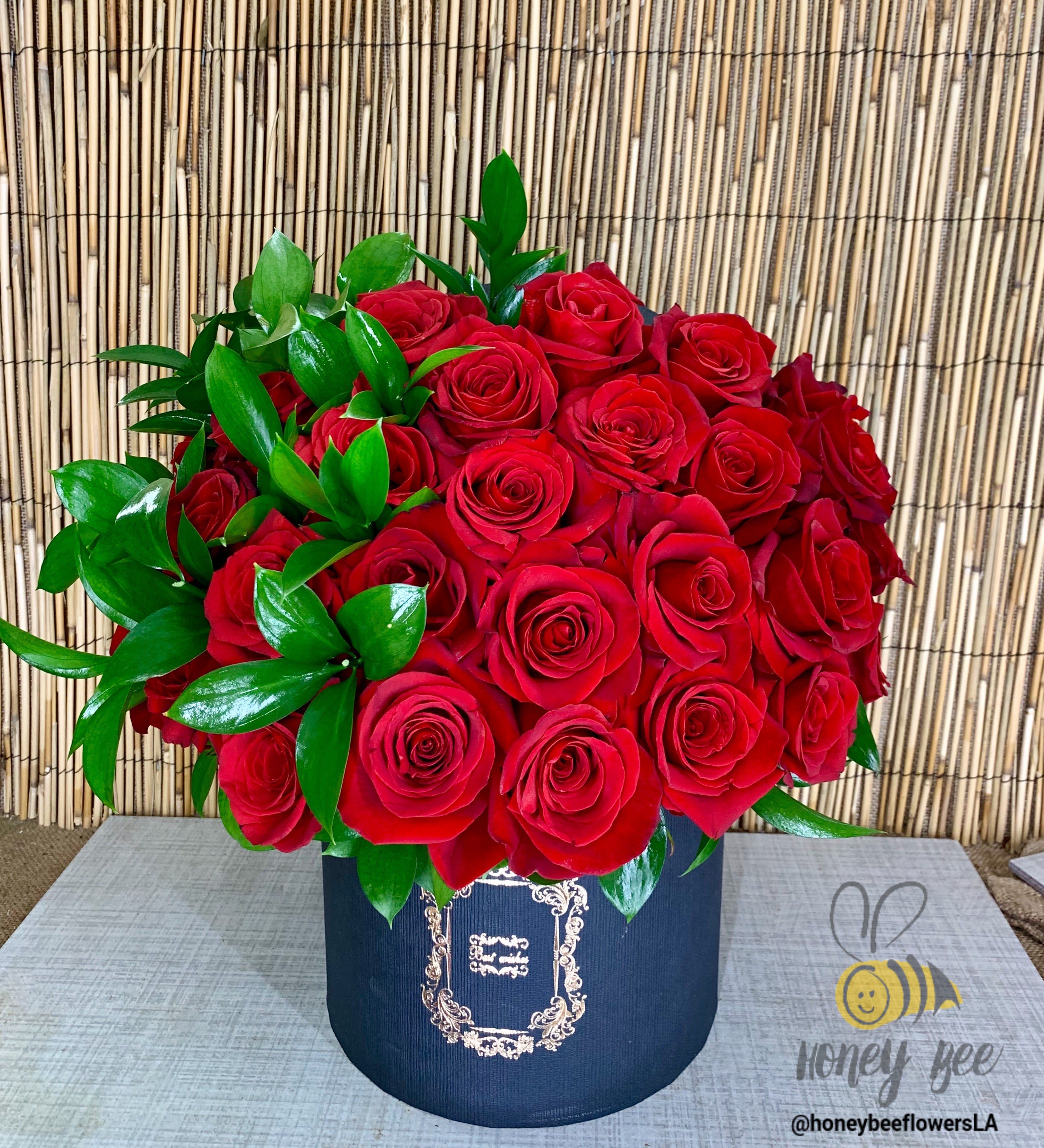 Roses in Hatbox - This modern rose arrangement is the hot new trend. Red roses artfully arranged in a black hatbox. You may customize the color of the roses, please let us know in the special instructions!  Standard - 2 dozen Deluxe - 2.5 dozen Premium - 3 dozen  
