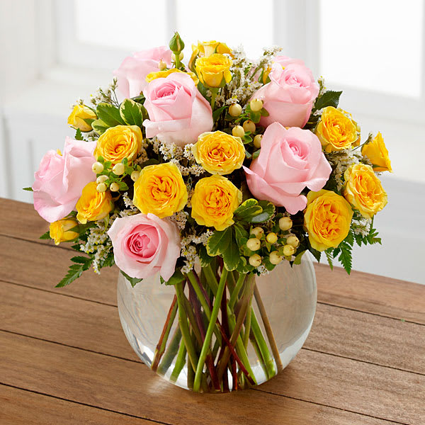 Soft Serenade Rose Bouquet - Soft Serenade™ Rose Bouquet is a sunny and charming flower arrangement set to spread your warmest wishes. Pink roses yellow spray roses white hypericum berries white limonium and lush greens are perfectly arranged within a clear glass bubble bowl vase to create a wonderful way to say thank you get well or to extend your congratulations.