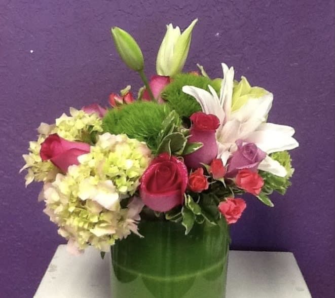 V134 - A high end low and compact arrangement of roses, lilies and hydrangeas. 