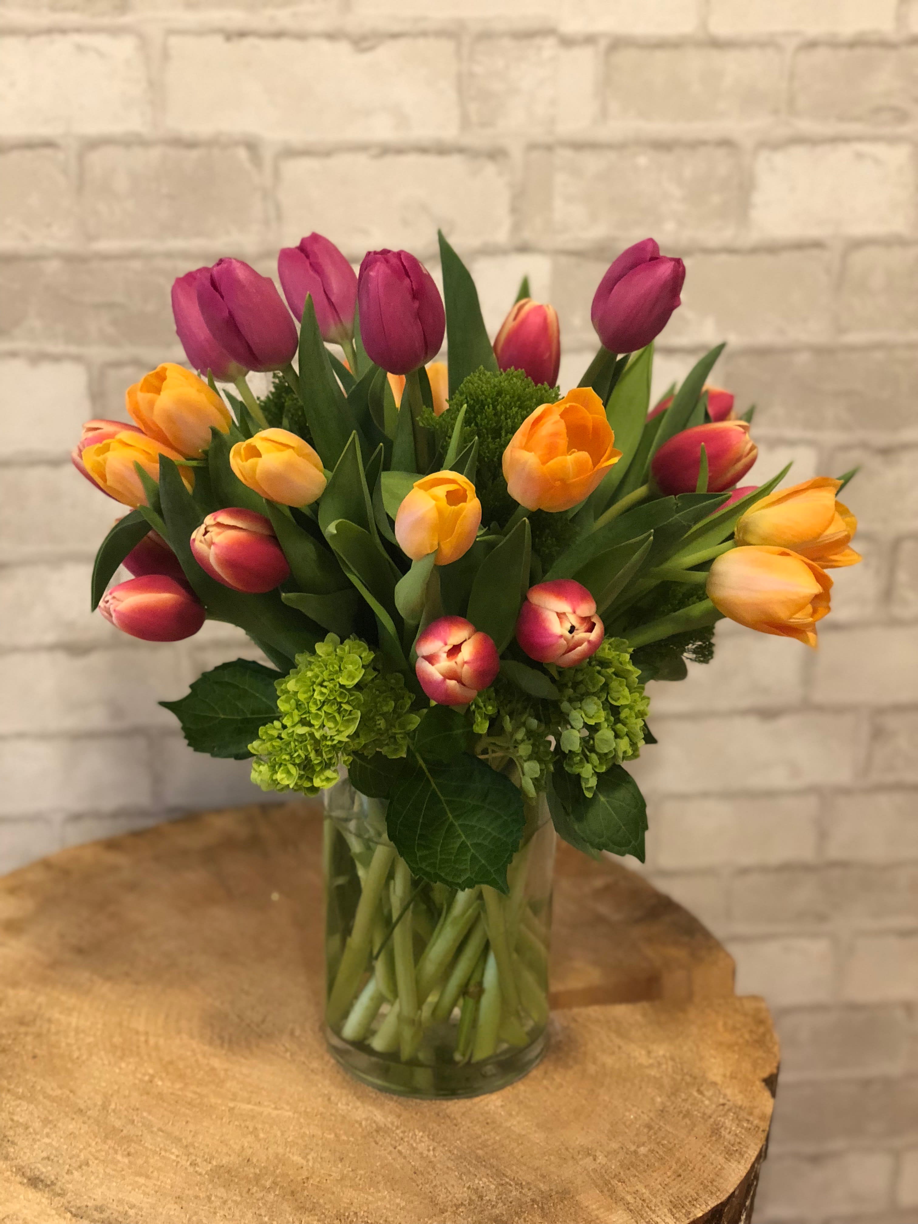 Spring Tulips - A plethora of color in a medium sized glass vase.  Nothing says spring is here quite like a trip-colored tulip arrangement.  Send some spring today!