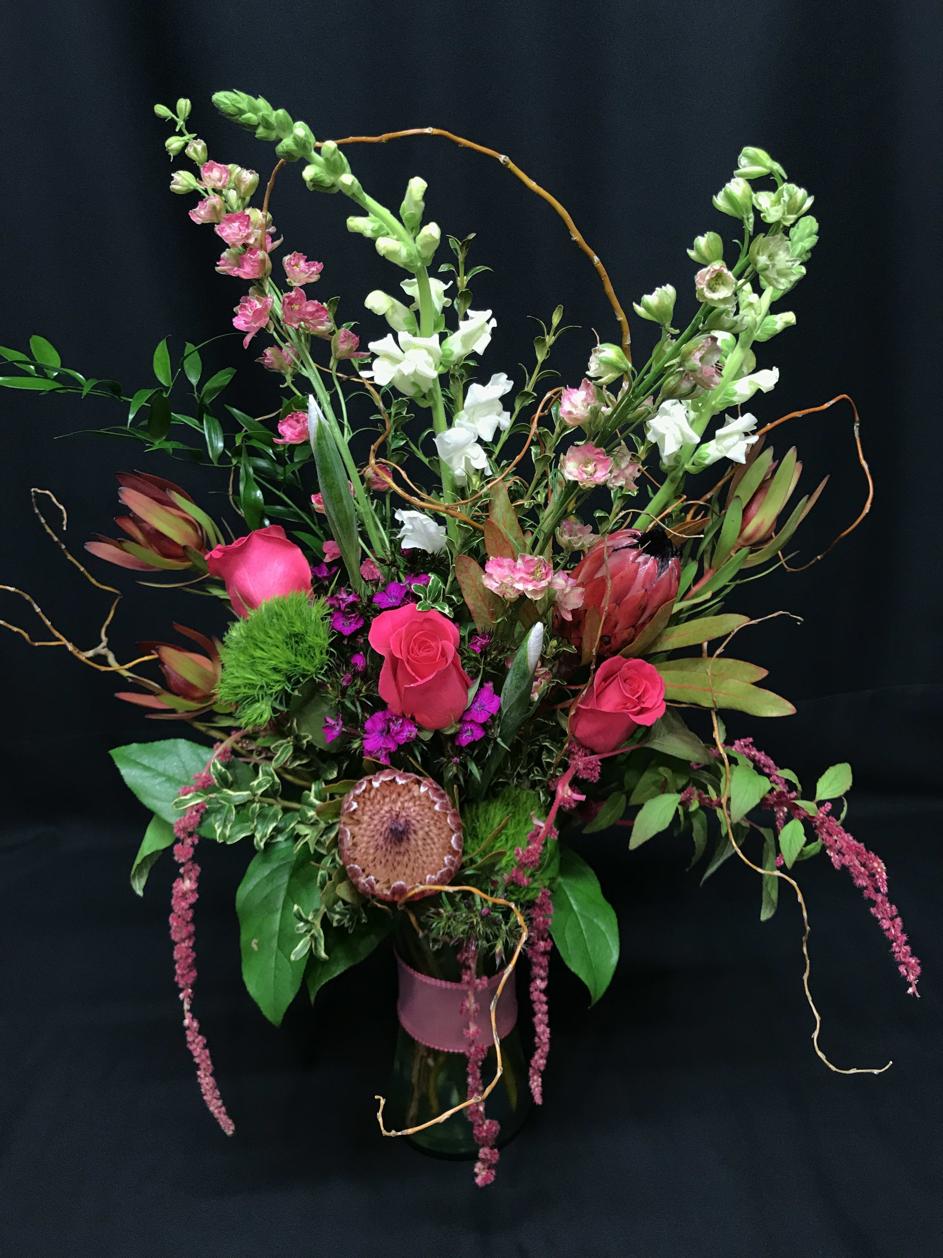 Wild romance bouquet with roses and protea - A whimsical romantic design to stir up your valentine. Modern and unique. Assortment will vary.