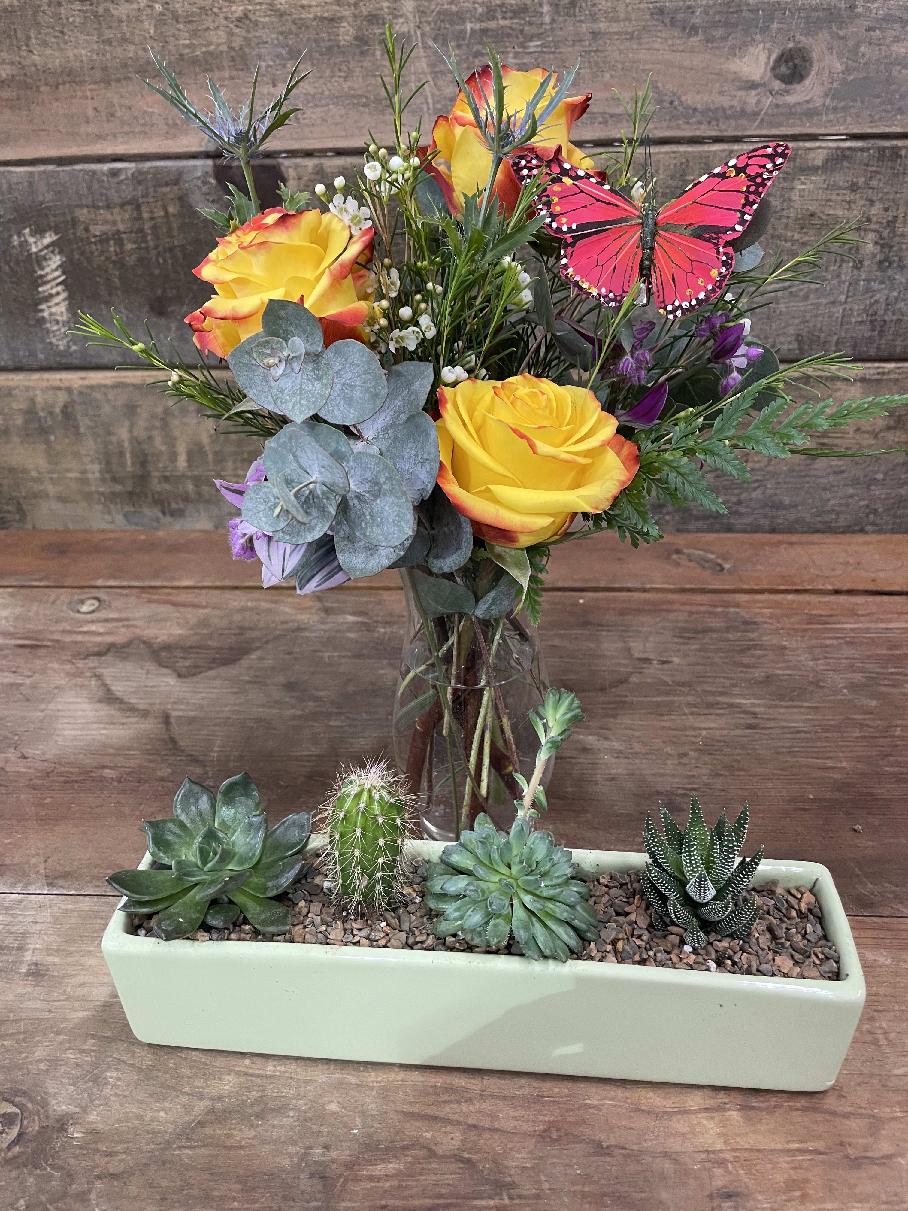 Succulents and Blooms - A succulent planter which has the ability to be mounted on the wall if desired. A bright floral design, perfect for a small table. Color of the succulent planter may change.
