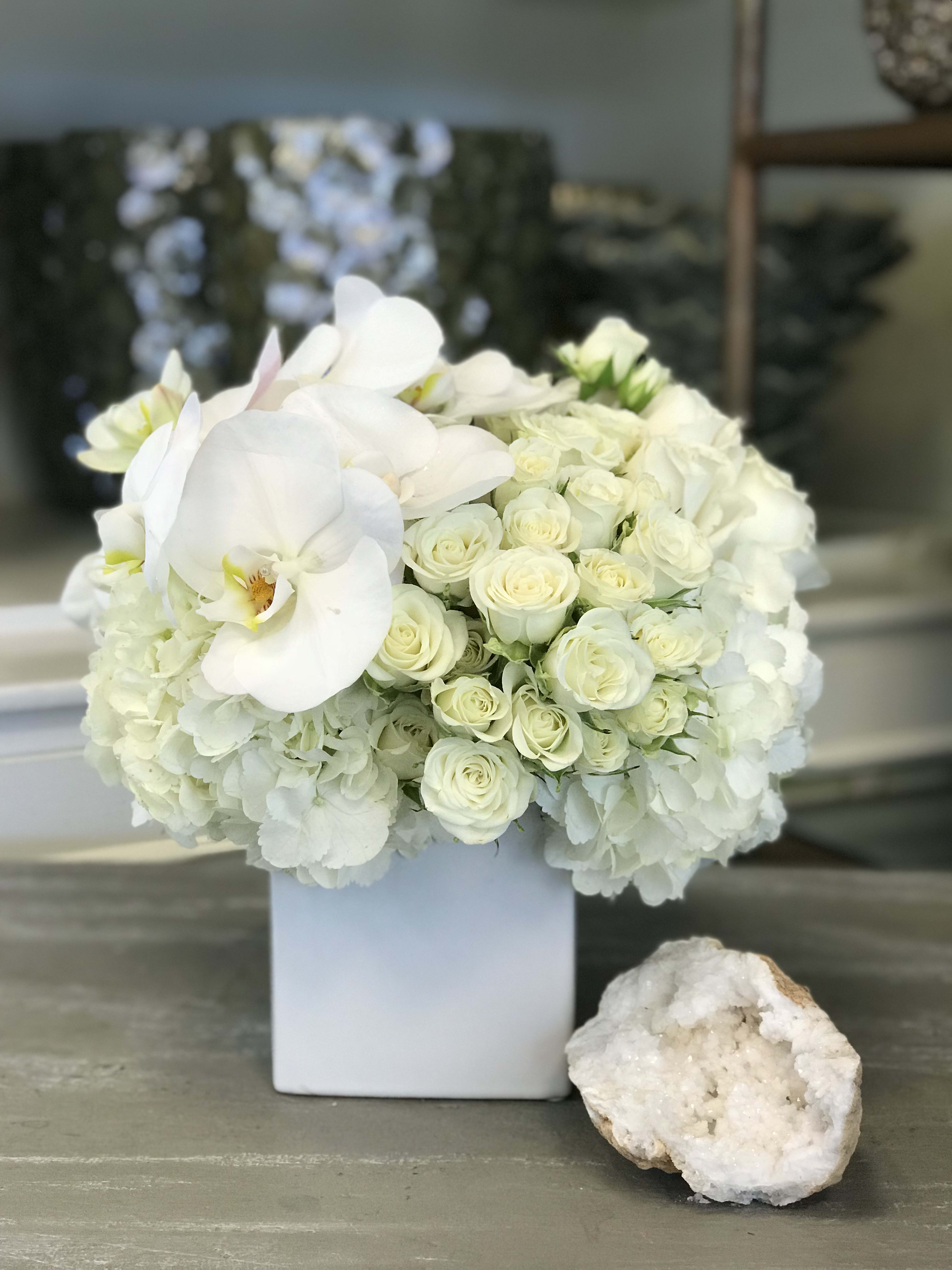 Pearl of The Sea - Pearl of the sea arrangement, features a beautiful bed of white hydrangeas, white Phalaenopsis orchids and white spray roses. For those who love simplicity and elegance this is the perfect choice. 
