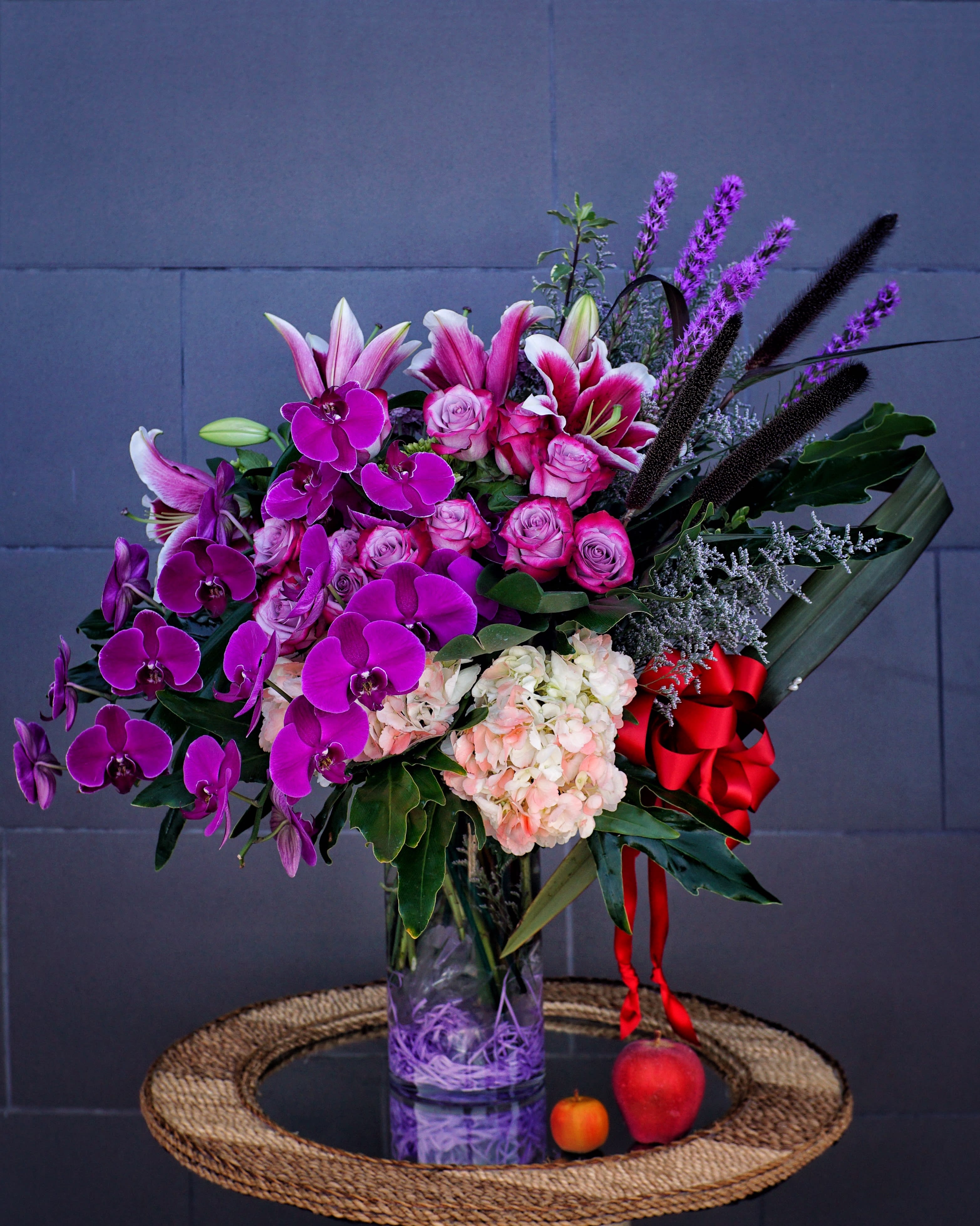 Purple Romance - Beautiful design including all premium fresh flowers: orchid, rose, lily... and nice accents in a tall glass vase. STANDARD: FIRST PHOTO DELUXE: SECOND PHOTO