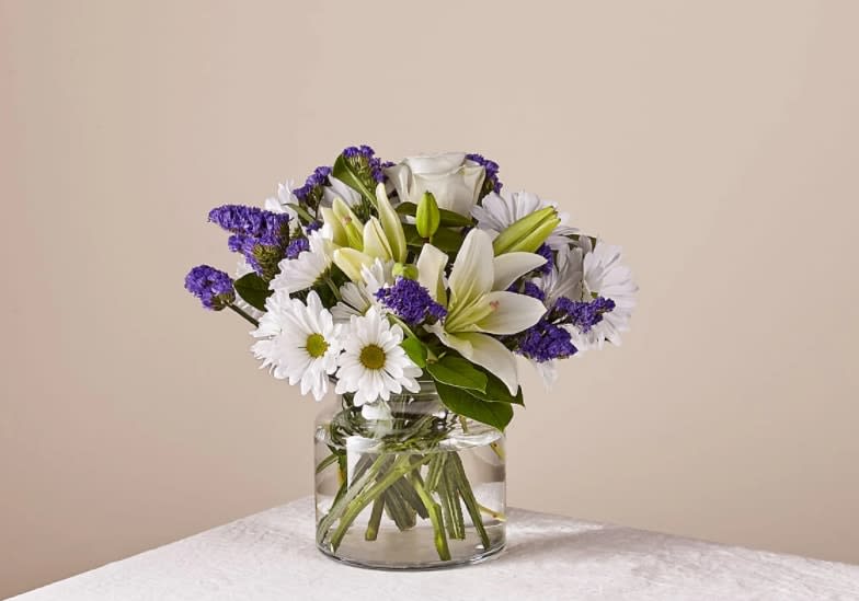 Beyond Blue Bouquet Beyond Blue Bouquet - There is something about the shade of blue that brings a sense of calmness and serenity. Our Beyond Blue bouquet is designed with billowing white blooms and pops of bold florals to deliver just the right sentiment for any reason. The Deluxe Bouquet is approximately 14"H x 13"W.