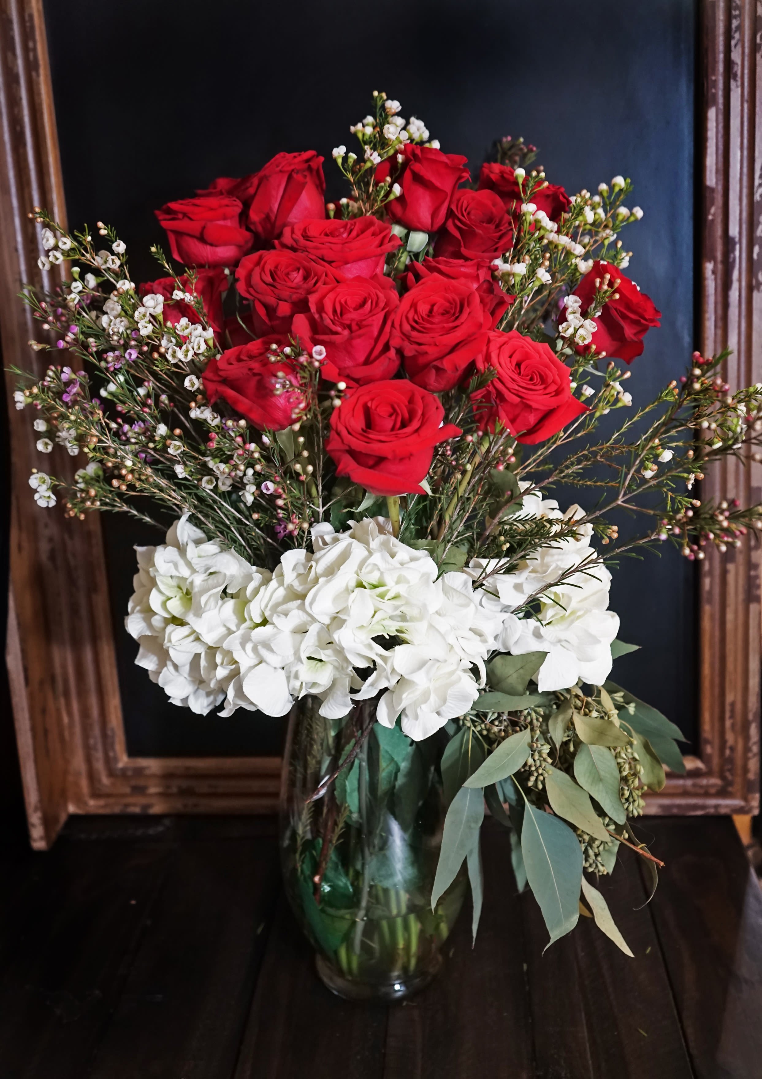 SOPHISICATED LADY - 2 Dz. Ecuadorian Red Roses - 2 Dozens Premium Red Roses with Waxflower Sprays, Hydrangeas, and Aromatic Eucalyptus mixed arrangement in a chic vase. 
