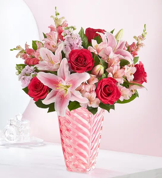 Simply Pink™ Bouquet - Simply pink. Simply spectacular! Our lovely arrangement is designed in a keepsake vase with a spiral design, celebrating the beauty of Depression era pressed glass. Created by Develyn Reed from 1-800-Flowers/Acara Florist, it’s the perfect gift to celebrate and connect with the people you care about.  All-around arrangement with hot pink roses and carnations, pink Oriental lilies, Peruvian lilies (alstroemeria), snapdragons and stock; accented with assorted greenery Artistically designed in our exclusive pink tapered, pressed glass vase with spiral detail that celebrates original pressed glass of the historic Depression era; a timeless vintage keepsake to cherish over time; measures 8.5&quot;H Extra large arrangement measures overall approximately 20&quot;H x 19&quot;W Large arrangement measures overall approximately 19&quot;H x 18&quot;W Medium arrangement measures overall approximately 18&quot;H x 16&quot;W Our florists hand-design each arrangement, so colors and varieties may vary due to local availability To ensure lasting beauty, lilies may arrive in bud form and will fully bloom over the next few days