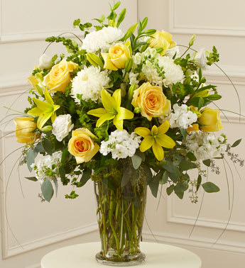 Beautiful Blessings Yellow Vase Arrangement - Product ID: 91298   Our florists use their expert skills and artistic abilities to create an elegant sympathy arrangement that includes yellow flowers as a symbol of friendship and hope, and white blooms to signify reverence and peace. Itâs a beautiful, fitting final tribute for a beloved family member, friend or colleague. Hand-designed arrangement of fresh yellow roses, white football mums, stock, snapdragons and more Accented with salal, seeded eucalyptus and more Presented in a footed clear glass vase; measures 11&quot;H Can be sent to the home of friends, family members or business associates, or directly to the funeral service Our florists choose only the freshest flowers available, so colors and varieties may vary Arrangement measures approximately 26&quot;H