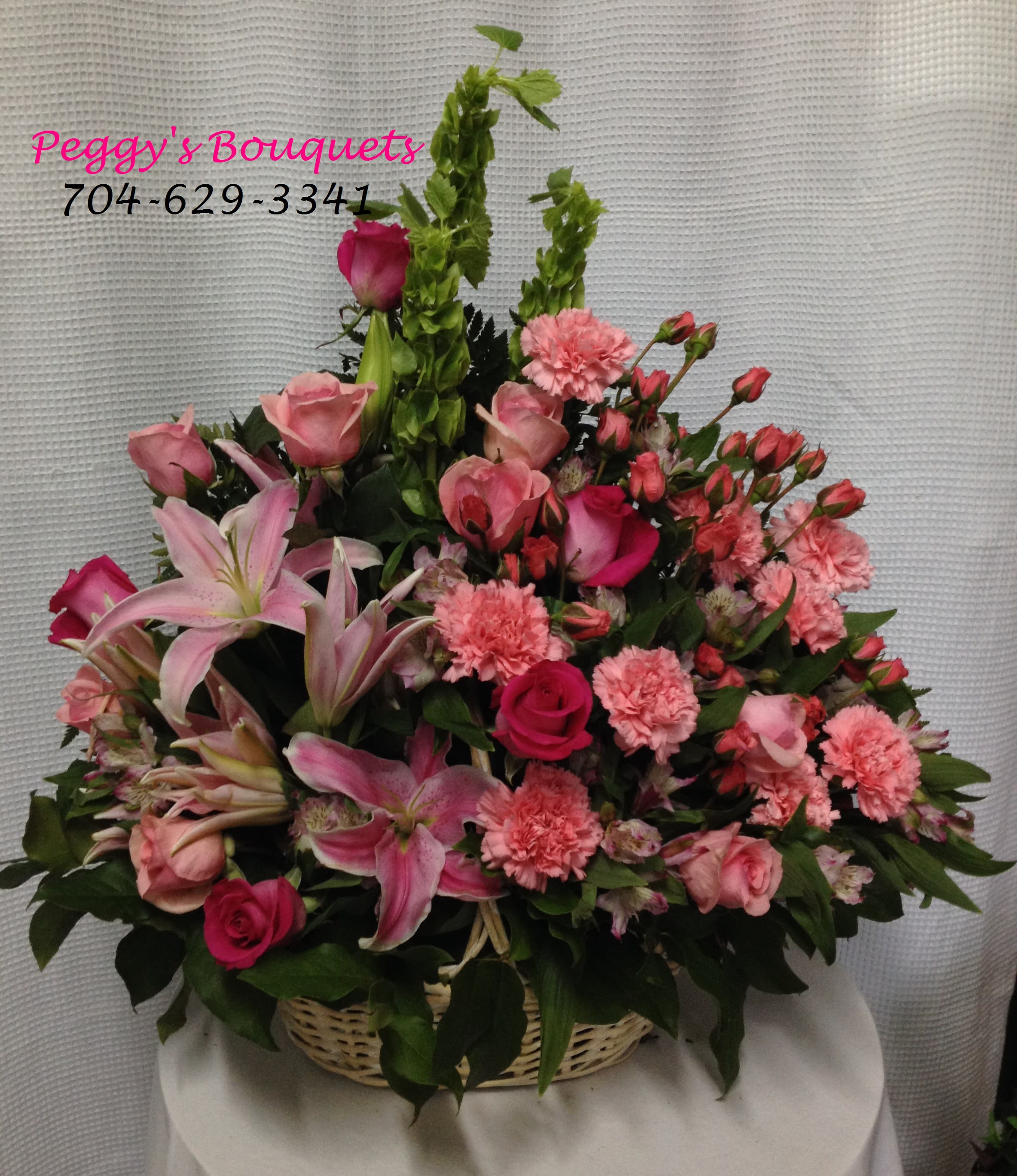Pink Delight Pink Delight - Beautiful basket of pink flowers. Carnations, roses, spray roses, pink lilies and bells of Ireland create a lovely blend of flowers in shades of pink. If pink is your passion, this basket is for you. Delight someone you love with a Pink Delight basket.
