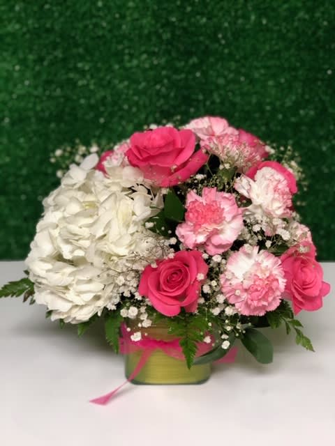 Elegance  in pink - Beautiful arrangement of white hydrangea in contrast with pink or similar roses and carnations, to give an impact of color, made in a 4¨x 4¨ glass cube