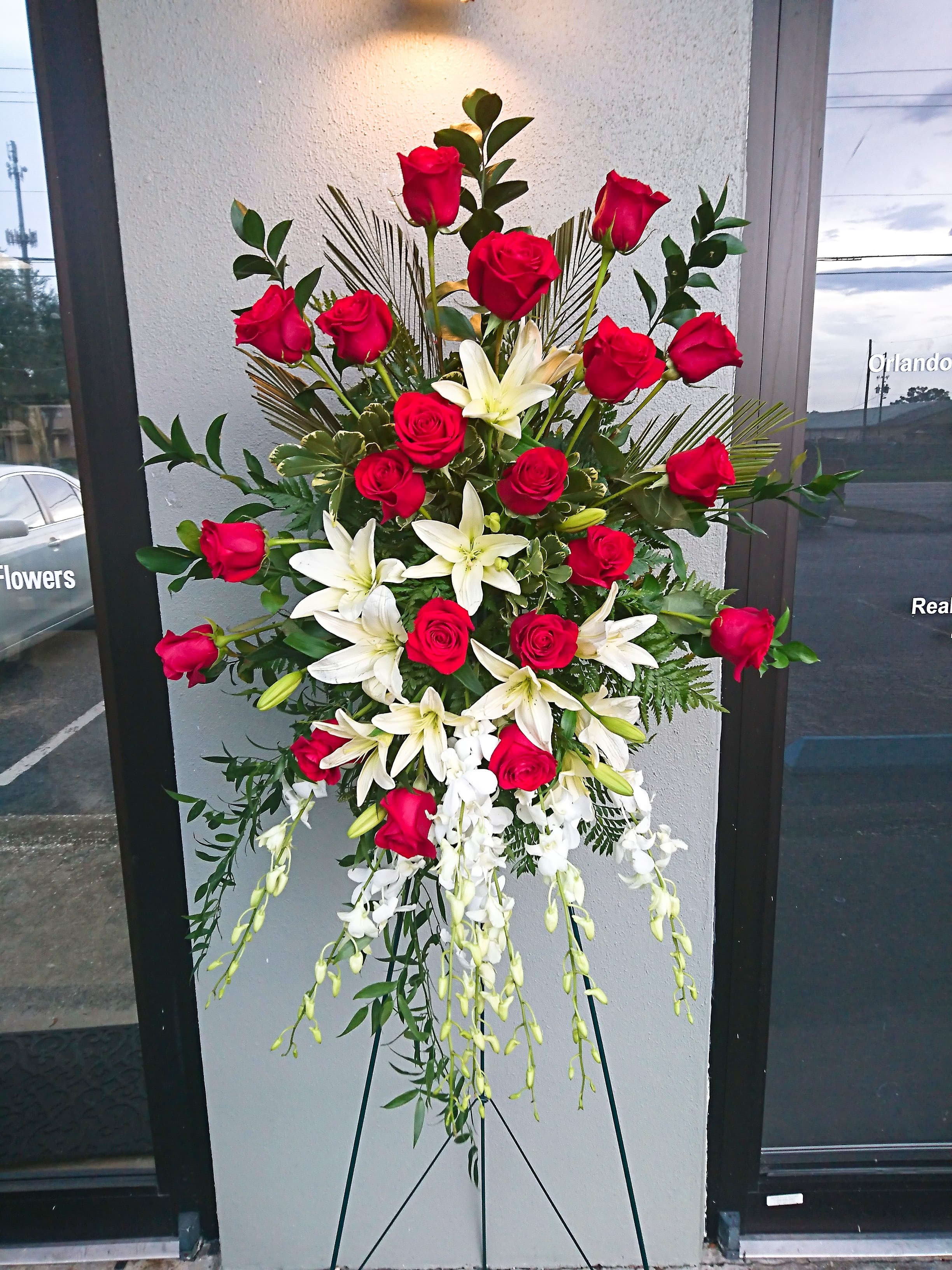 Lily and Rose Tribute Spray Lily and Rose Tribute Spray - Pure white lilies and dendrobium orchids mingle with red roses, white asiatic lilies and more in this magnificent and impressive standing spray of the finest blooms. A fitting tribute for a funeral, wake or memorial service. Approximately 31" W x 50" H