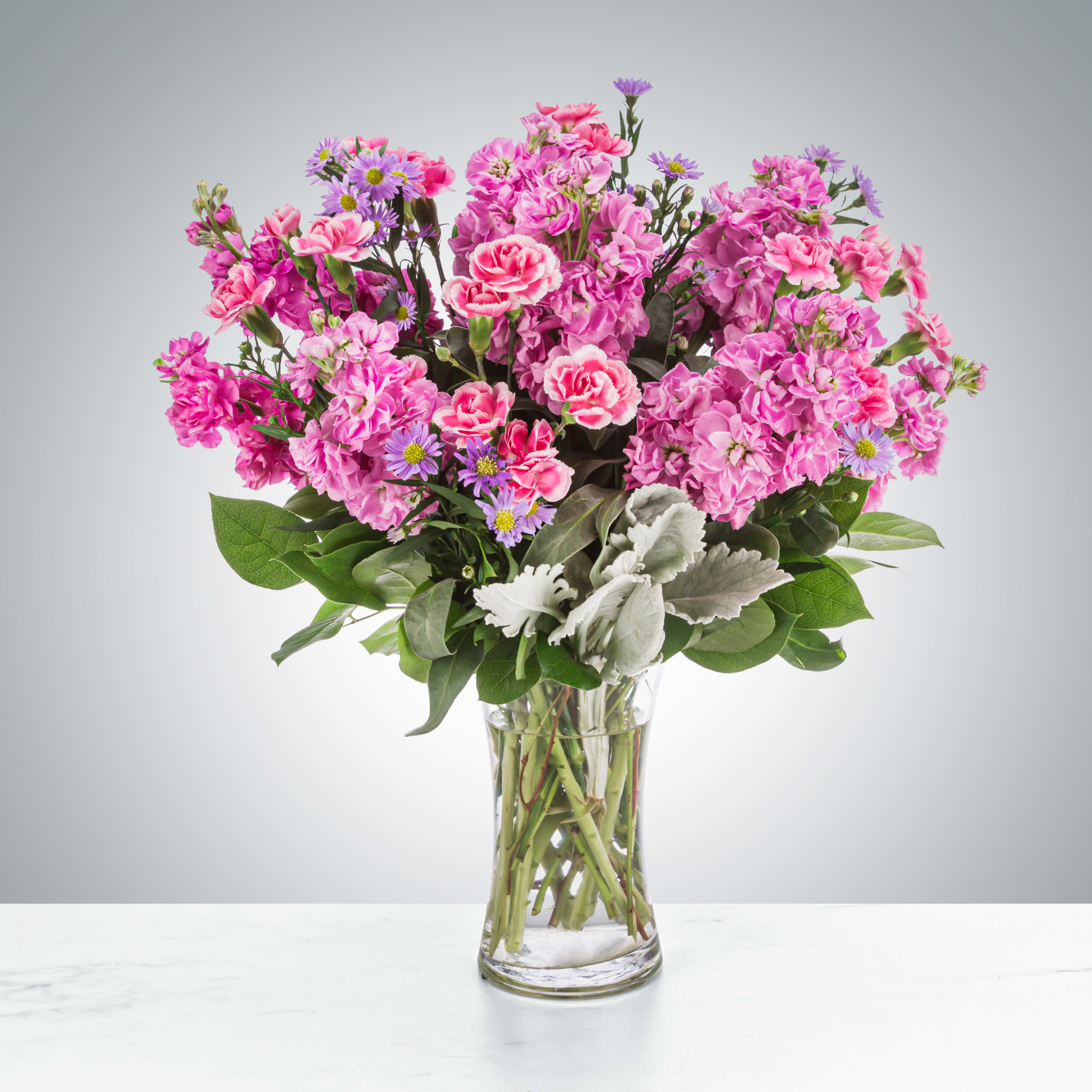 Uptown Girl by BloomNation™ - This arrangement is a pink and purple confection featuring sweet-smelling stock flowers and purple asters. A great gift for birthdays, women's day, or breast cancer awareness month.  Approximate Dimensions: 12&quot;D x 17&quot;H