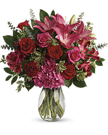 Love Struck Bouquet - A luxurious bouquet that's sure to leave your special someone absolutely love struck! There's no denying the dramatic beauty of these radiant, red hot roses, hydrangea and lilies.  This luxe arrangement includes pink hydrangea, hot pink roses, red roses, dark pink asiatic lilies, dark pink alstroemeria, maroon carnations, pitta negra, spiral eucalyptus, and lemon leaf. Delivered in a glass jordan vase.  SUBSTITUTION POLICY – Always deliver the freshest flowers! Please note the bouquet pictured reflects our original design.  If the exact flowers or container in this arrangement are not available, we will create a beautiful bouquet with the freshest available flowers.