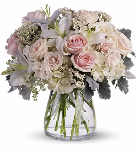 Beautiful Whisper - A whisper-quiet affirmation of love. Subtle shadings of pink and white roses lilies and delicate Queen Anne's lace in a simple elegant vase. Gorgeous flowers such as white cr?me and light pink roses white oriental lilies and delicate Queen Anne's lace with a touch of silvery dusty miller all in a classic hurricane vase.Approximately 15 1/2&quot; W x 15 1/2&quot; H Orientation: All-Around As Shown : T237-1A
