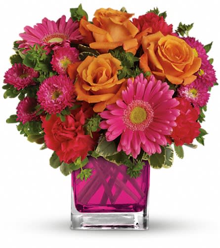 Teleflora's Turn Up The Pink Bouquet - Turn up the heat with this hot pink haute couture creation! Super chic and oh-so-fun in its fuchsia Cube vase this girly mix of gerberas and roses is sure to warm her heart. This brilliant bouquet of lush orange roses hot pink gerberas carnations and matsumoto asters are accented with bupleurum and variegated pittosporum. Delivered in a glass Cube.Approximately 11&quot; W x 11&quot; H Orientation: One-Sided As Shown : TEV33-1ADeluxe : TEV33-1BPremium : TEV33-1C