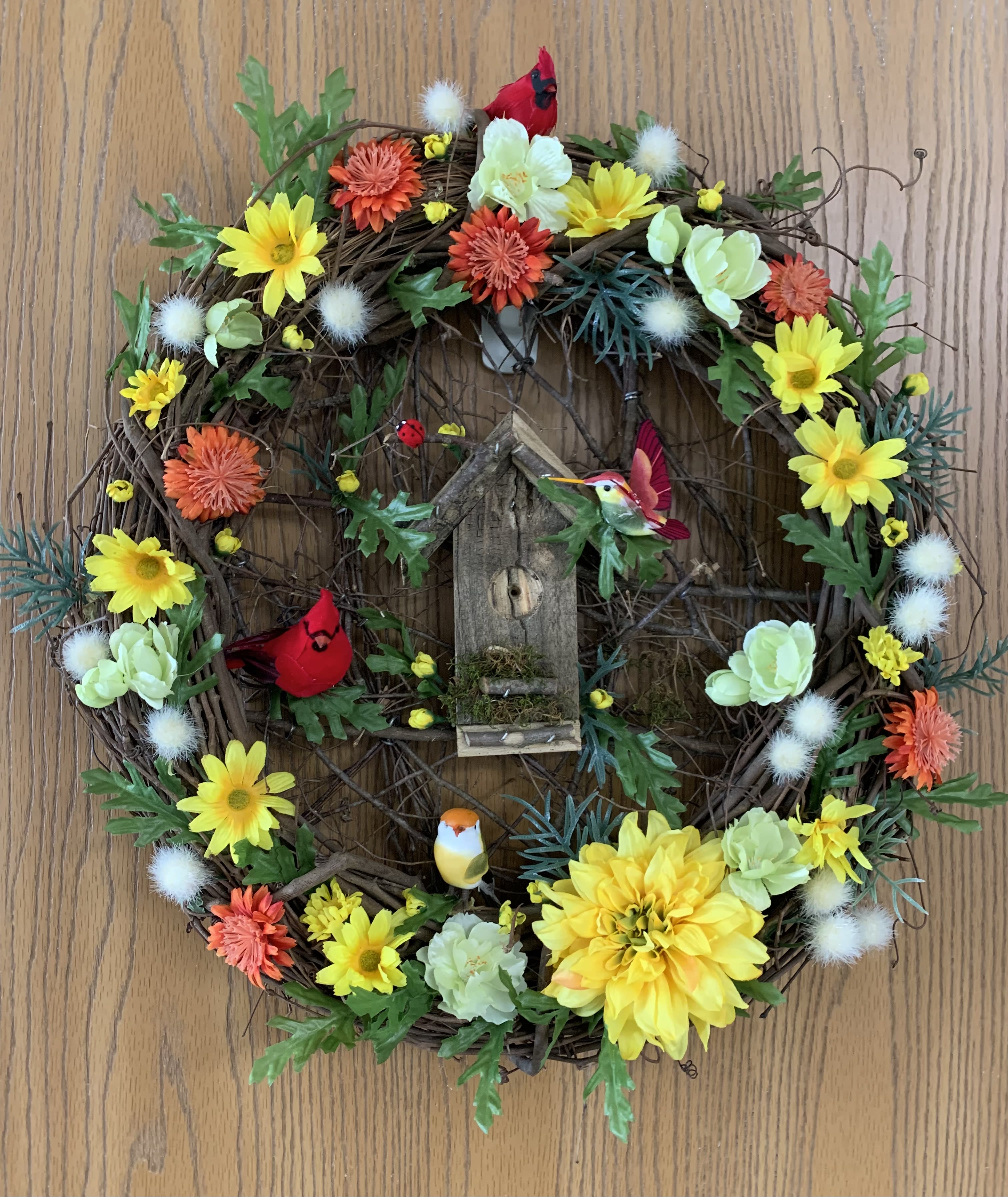 Birdhouse Wreath Birdhouse Wreath - A cheerful grapevine wreath with silk flowers, birds and a birdhouse.