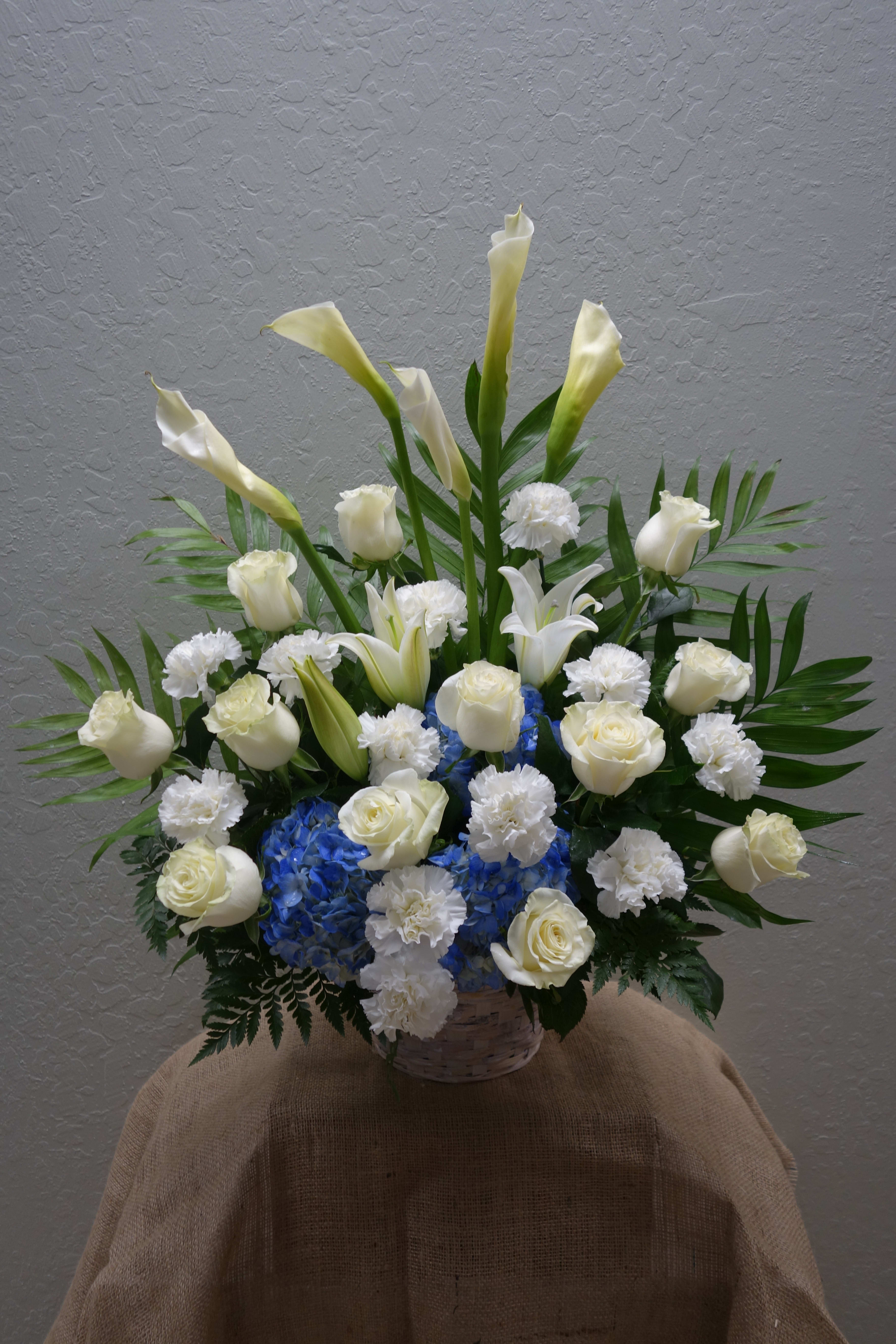 FB#10 Heavenly Skies Basket - Lovely like the blue skies and pure white like the clouds, a beautiful sympathy arrangement that features hydrangeas, roses, carnations, lilies and calla lilies, and mixed foliage.  The arrangement is approximately 24&quot; H and 24&quot; W.