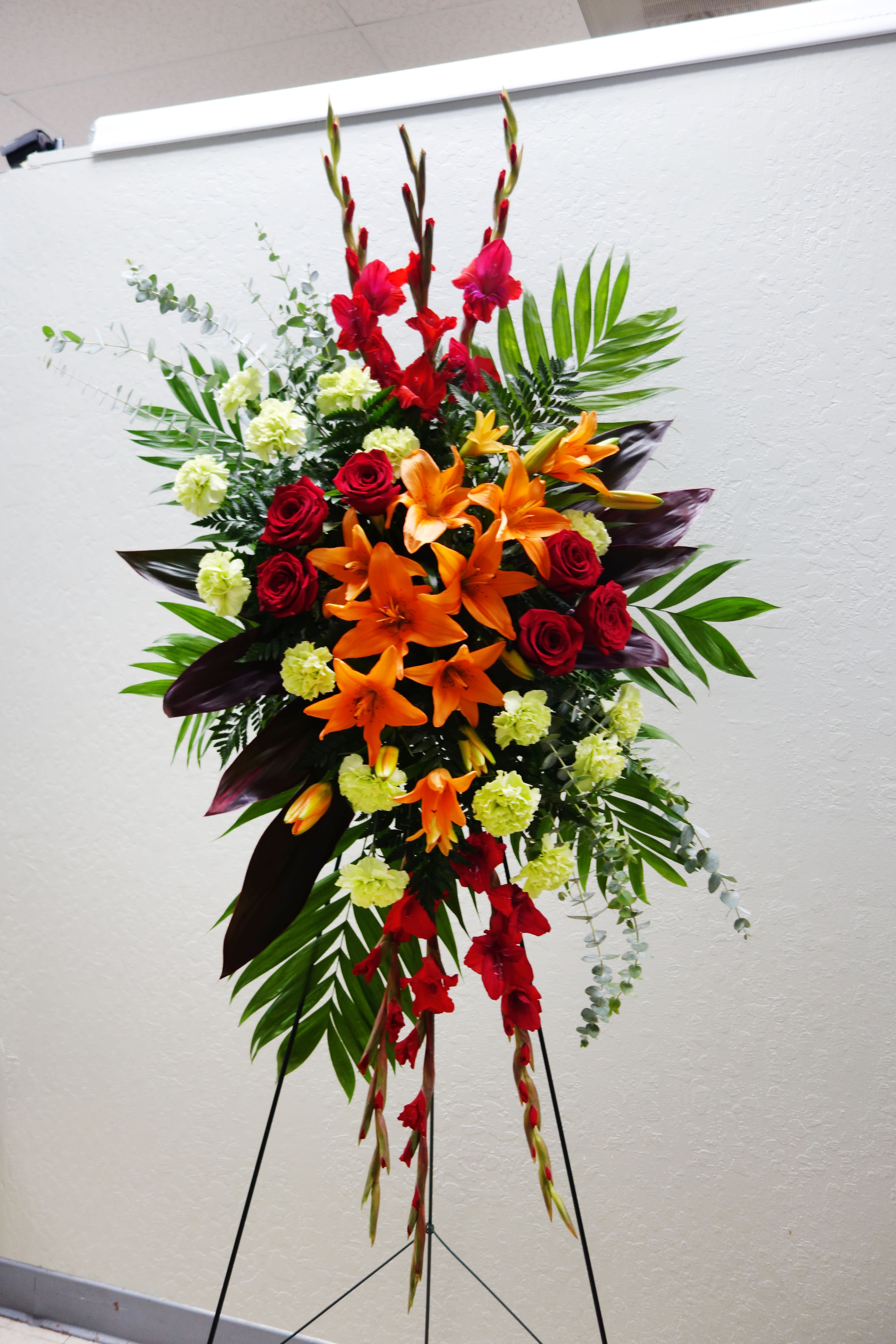 SS#08 A New Sunrise Spray - When a loved one has passed, this radiant spray of red and orange flowers will be a reminder of happy times past that will never be forgotten.  The arrangement is approximately 48&quot; H and 24&quot; W.  Standard (as shown)