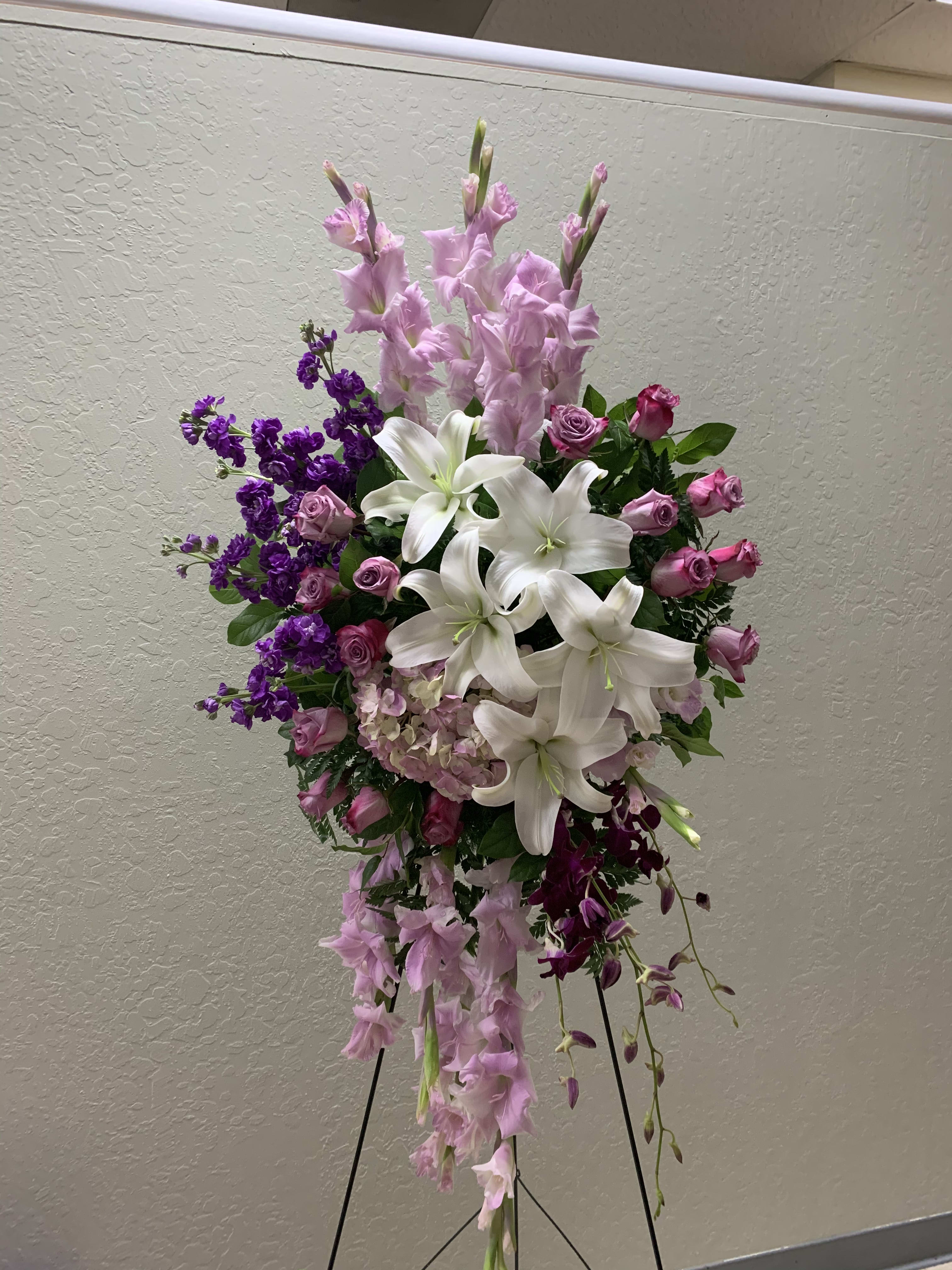 SS#18 Regal Purple and White Spray  - Standing spray of white asiatic lilies, lavender gladiolus, purple stock, purple roses, purple dendrobium orchids, purple hydrangea, and mixed foliage.   The arrangement is approximately 48&quot; H and 24&quot; W.  Standard (as shown)