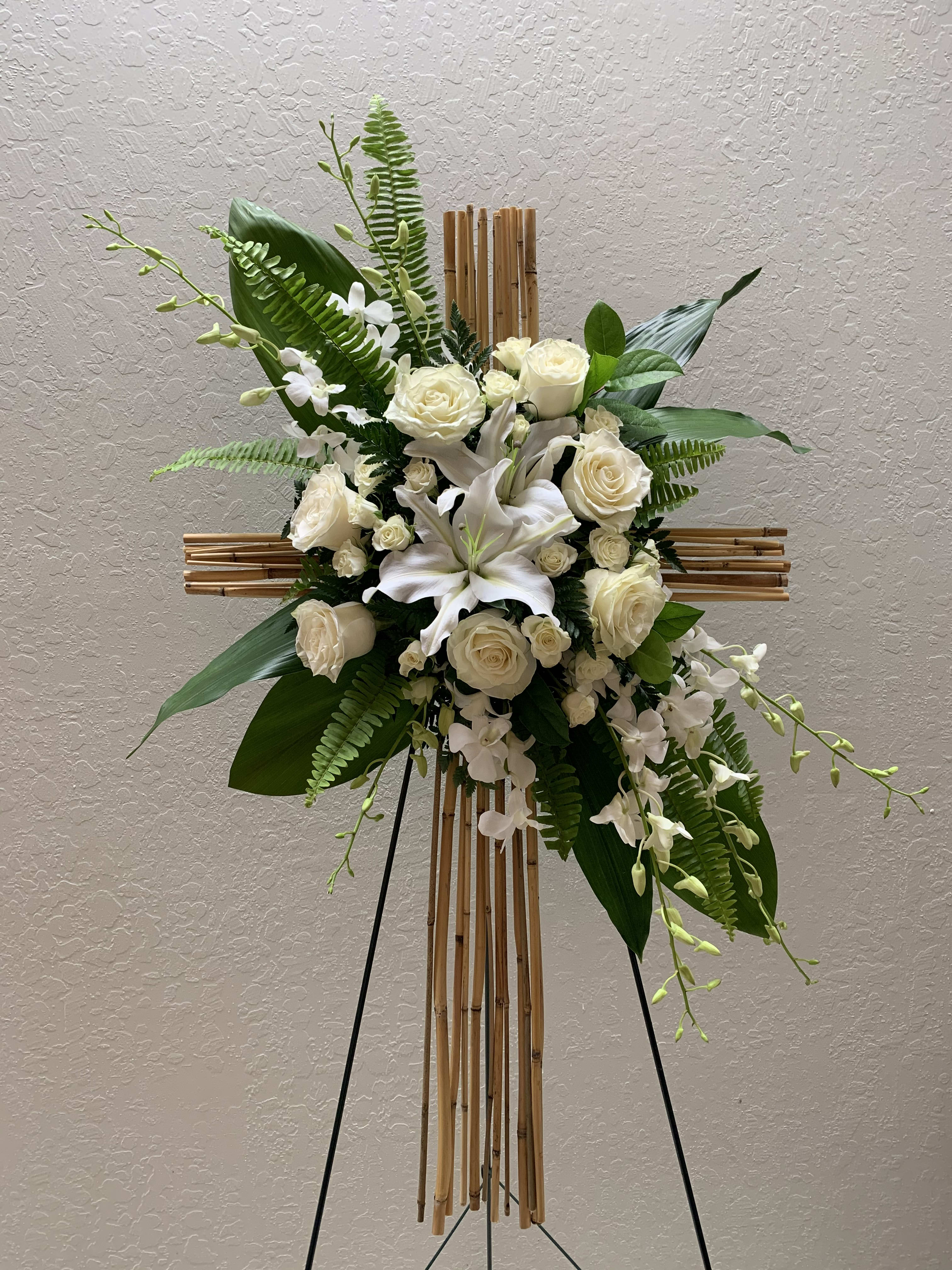 CR#05 White Tropical Celebration Cross Spray  - Cross is fashioned from river cane and decorated with white roses, white lilies, white dendrobium orchids, white spray roses, and tropical foliage. Orientation: One-Sided  All sizes: Cross 40&quot; H Deluxe (As shown)