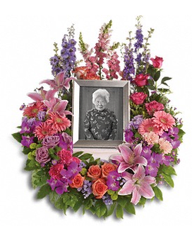 In Memoriam Wreath In Memoriam Wreath - Devotion is expressed and beautiful memories cherished with this deep-hued and softly elegant wreath. A lovely reminder of your affection and respect. A mix of dramatic flowers such as purple orchids and asters orange dark pink and lavender roses pink and peach carnations lavender larkspur green chrysanthemums and a range of pink blooms including oriental lilies gerberas snapdragons and more. Please note: Arrangement does not include picture frame. Approximately 26" W x 31" H Orientation: One-Sided T253-1Aa