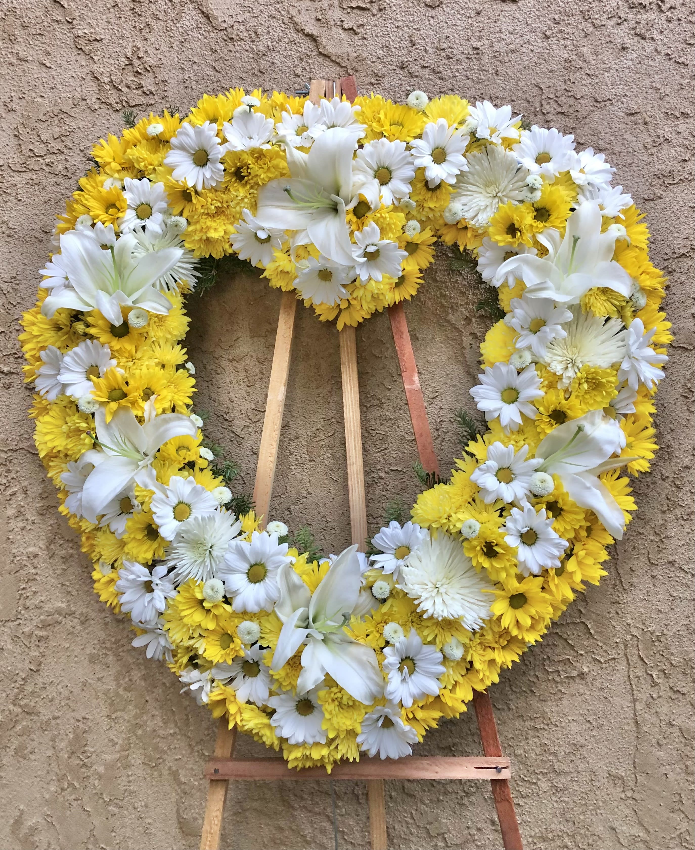 Vibrant Yellows - Beautiful standing funeral spray arrangement with yellow and white mixed flowers. Featuring lilies, daises, mums, and green accents.