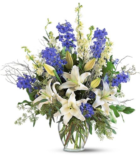Sapphire Miracle Arrangement Sapphire Miracle Arrangement - Brighten a room with this gorgeous arrangement filled with blue delphinium, white larkspur and lilies. Delphinium, larkspur, lilies and eucalyptus arrive in a clear glass ginger-shaped vase. Approximately 24" W x 29" H