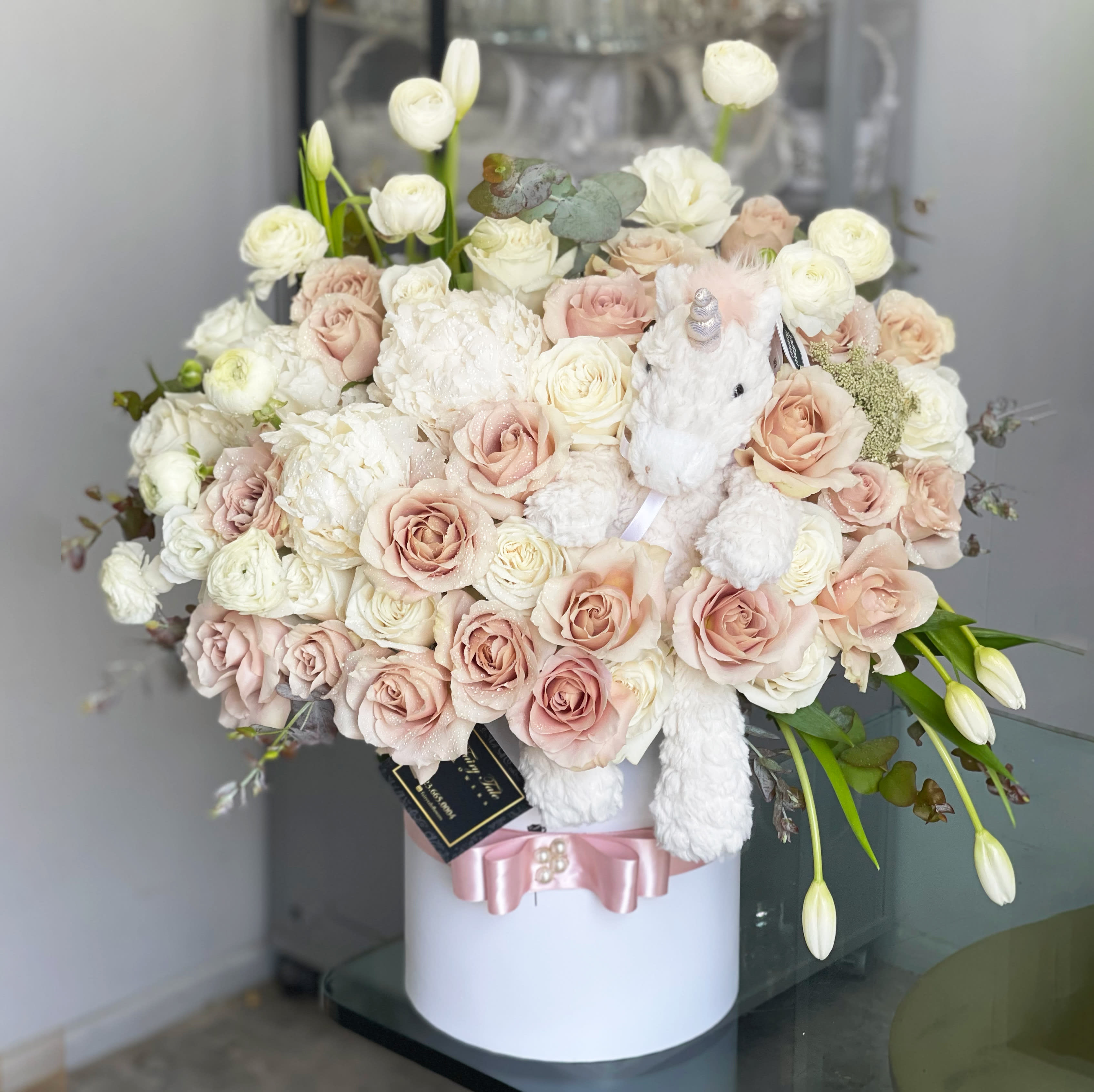 My unicorn - A beautiful newborn baby arrangement with white, blush, and green roses with tulips and peonies. Also includes a stuffed animal upon availability.