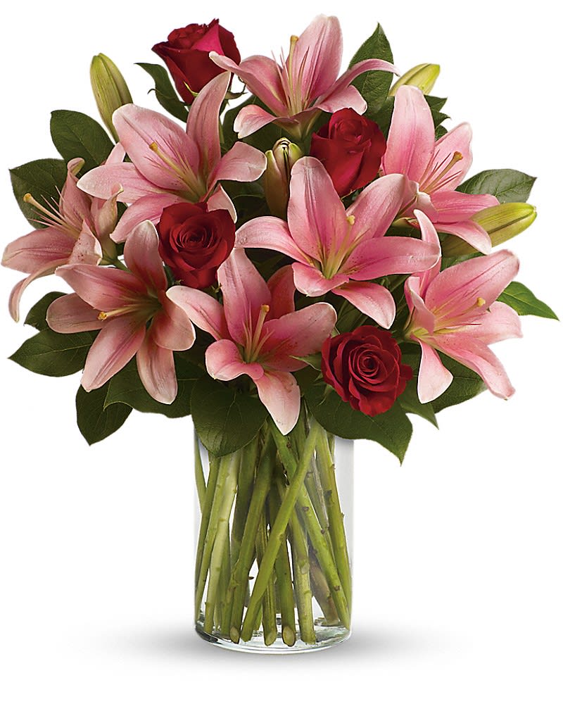 So Enchanting Bouquet - Turn an ordinary day into an enchanting daydream by sending her this magical bouquet! This stunning bouquet of rich red roses and magnificent pink lilies pampers her senses, refreshes her spirit and shows her how much you really care. Includes red roses, pink lilies and fresh lemon leaves. Delivered in a glass cylinder vase.