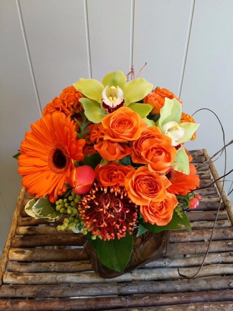 Lime &amp; Citrus - A bold display of orange &amp; lime green with gerbera daisies, spray roses, celosia,  protea, tulips &amp; cymbidium orchids.