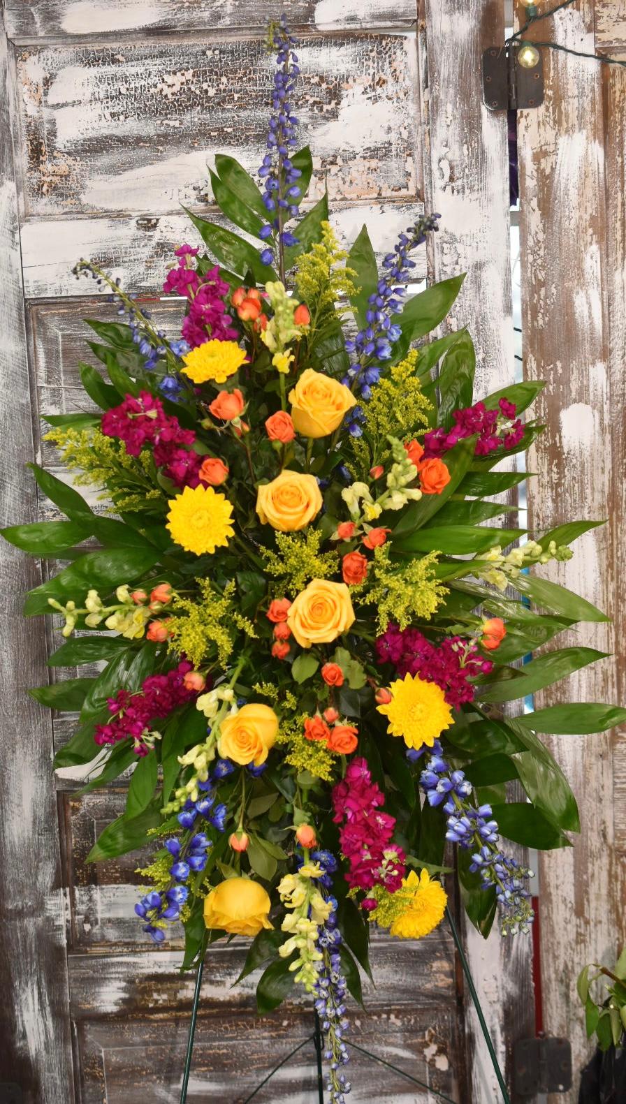 Colorful Standing Spray - A vibrant and beautiful standing spray filled with yellows, oranges, blues, and hot pinks.
