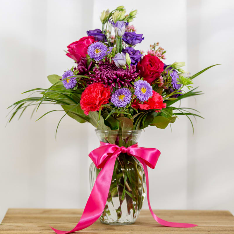 Mademoiselle - Ginger jar of raspberry and grape hues, plumspider mums, lavender chinese esters, hot pink carnations, pink waxflower, hot pink garden roses, 