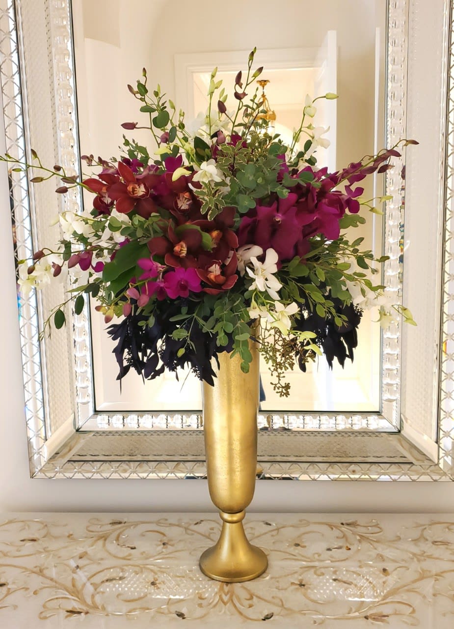 Orchid Love - Tall stately Orchid arrangement in bold colors including deep purples and magentas, surrounded by lush greens.