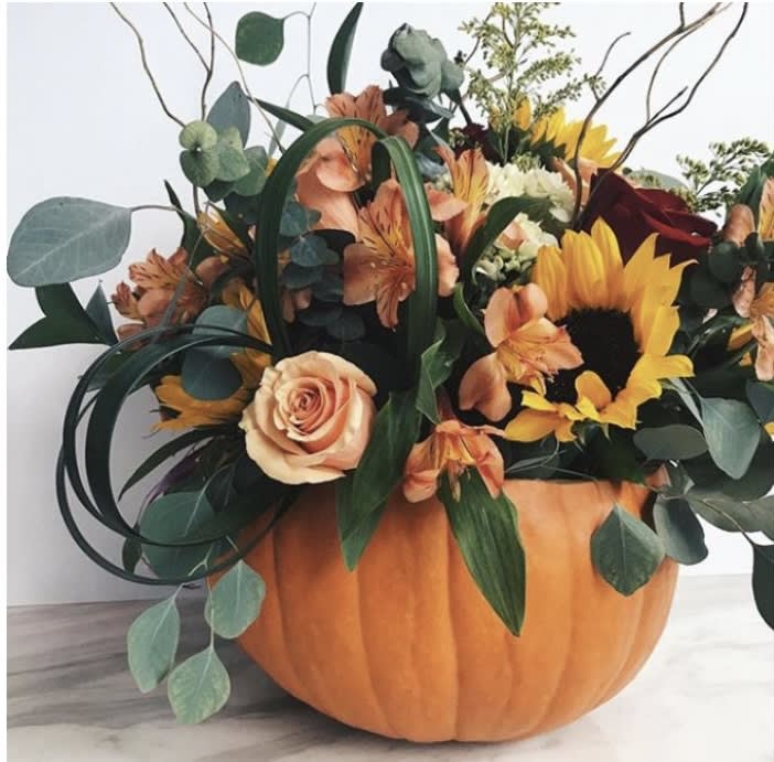 real pumpkin, orange and red roses, eucalyptus, sunflowers by