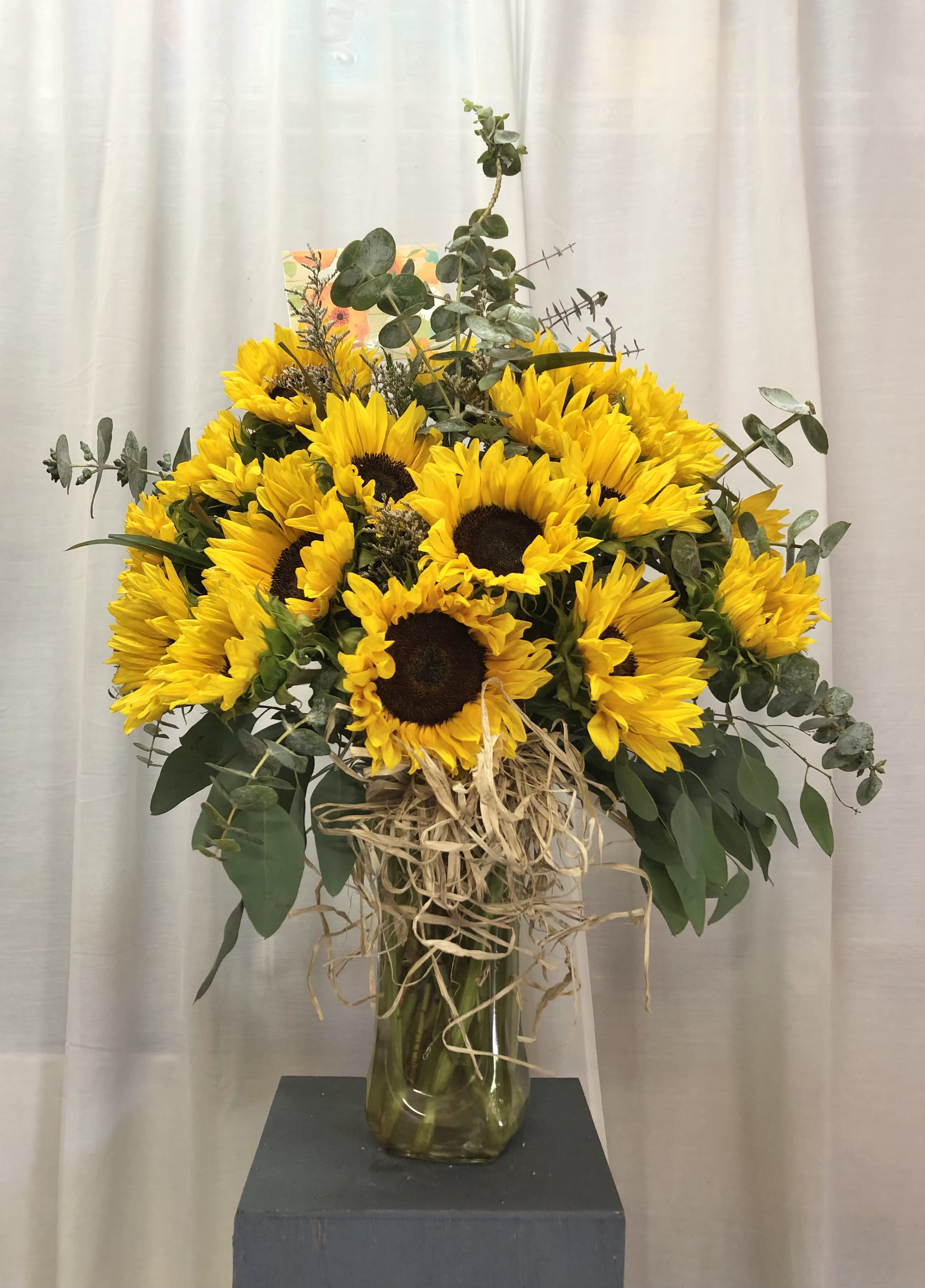 Eternal Radiance - Beautiful and vibrant arrangament featuring sunflowers with eucalyptus green accents.