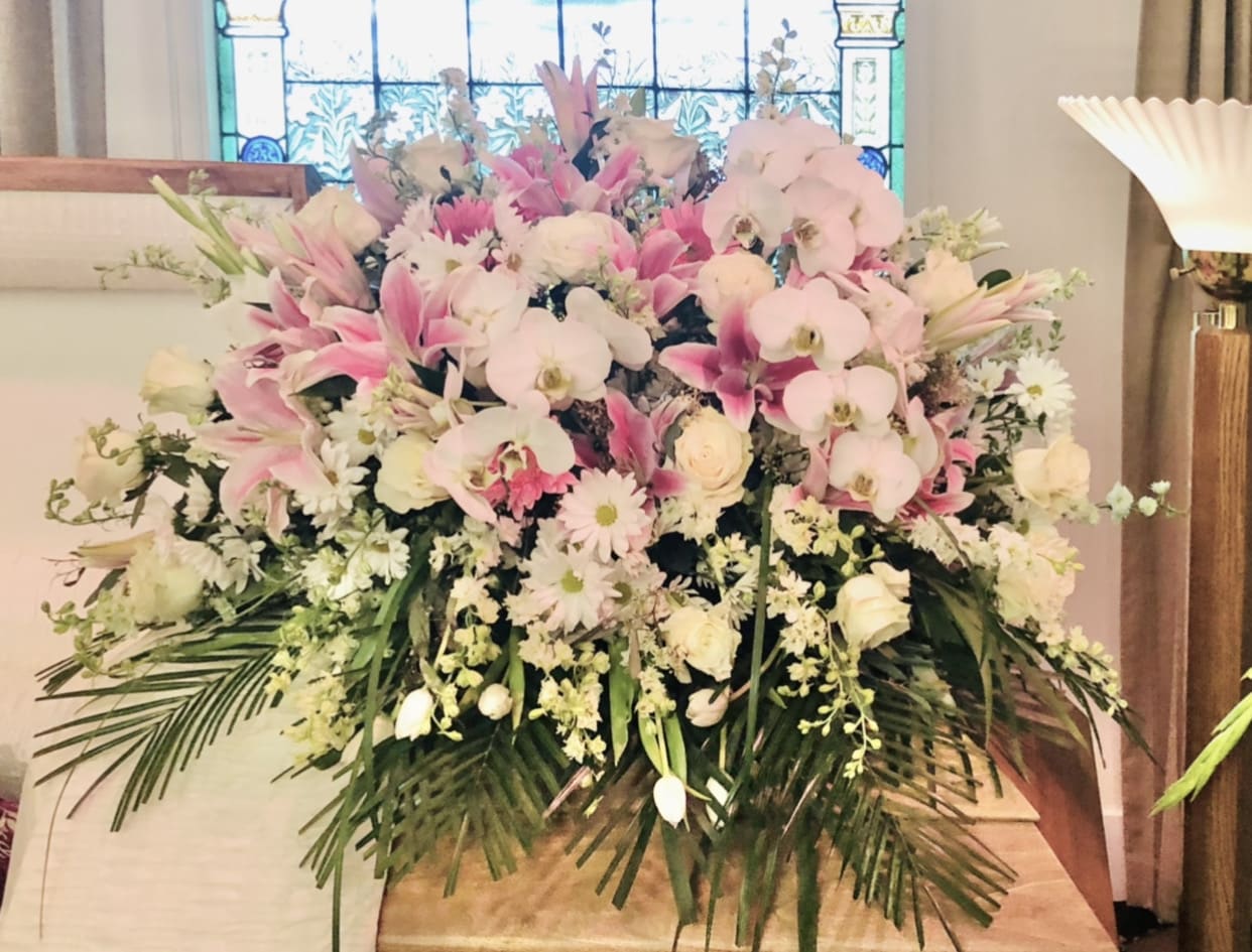 Casket 1 - Beautiful casket arrangement with pink lilies, orchids, tulips, roses, and green accents.