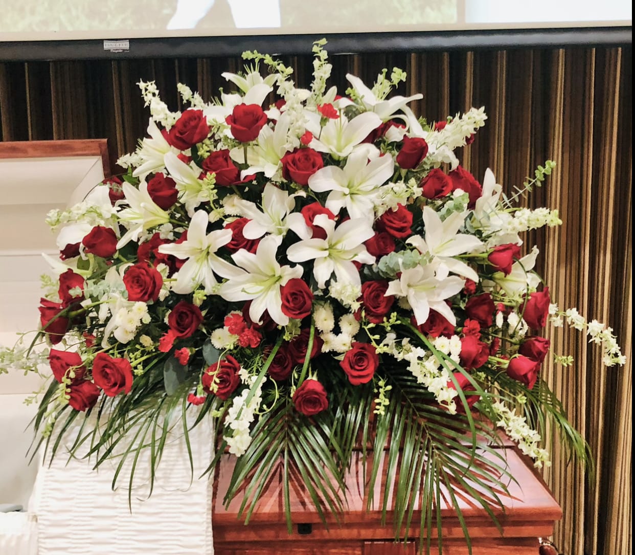 Casket 3 - Beautiful red and white casket arrangment featuring roses, lilies, orchids, daises, carnations, and green accents