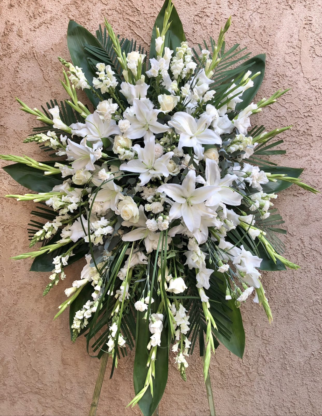 Grace - Beautiful white standing funeral spray arrangement featuring lilies, gladius, carnations, and green accents.