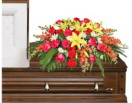 In Loving Memory Casket Spray - A loving combination of hot pink roses, red carnations, peach snapdragons, yellow lilies and white mums. The standard option is pictured.