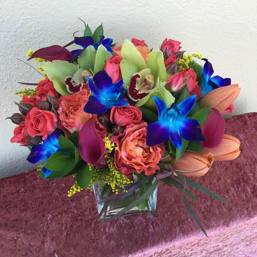 Spring Into Tropics - A unique design of gorgeous blue dendrobium orchids, mixed with green cymbidium orchids, tulips, roses, and cala lilies