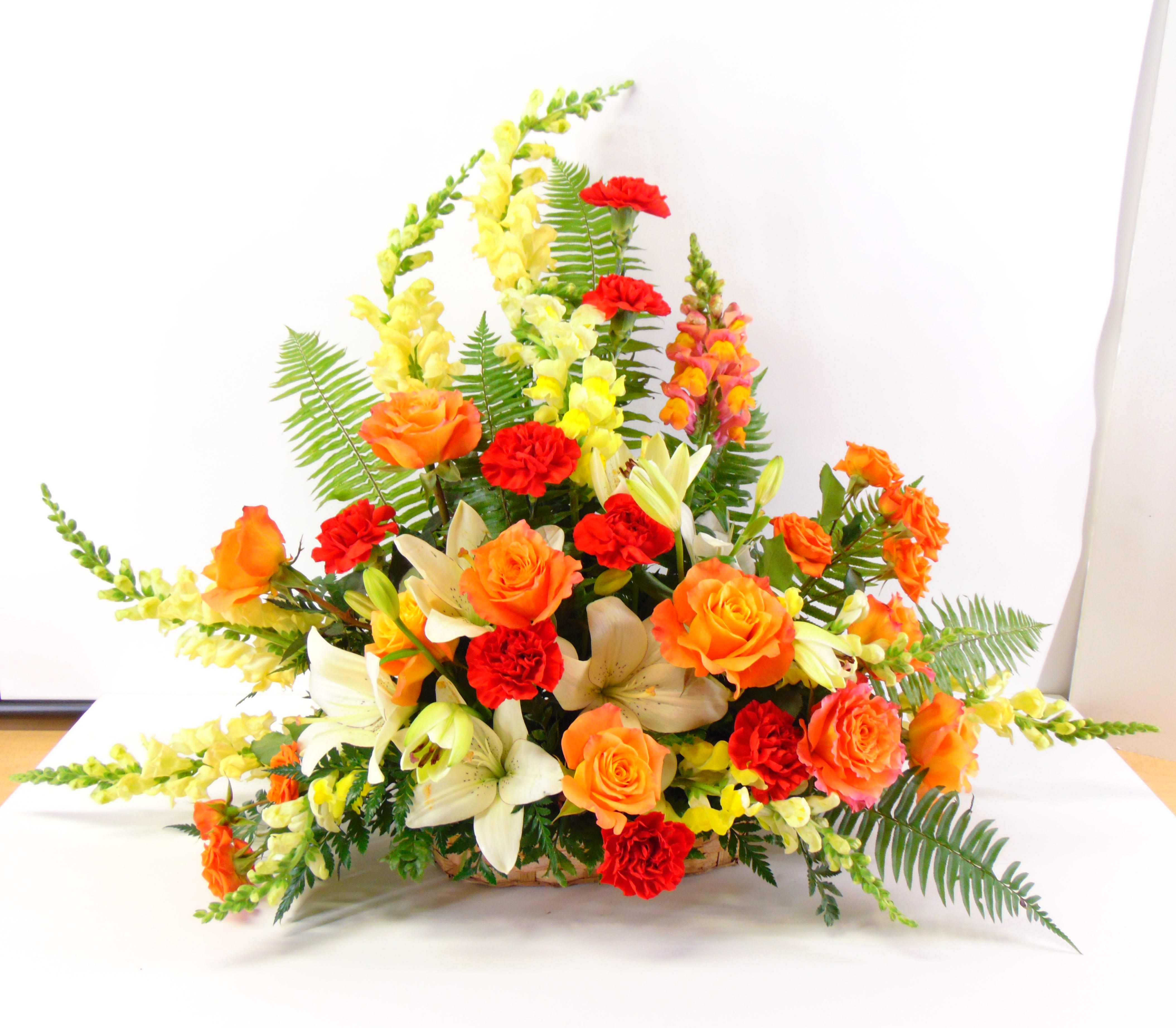 Golden Memories Arrangement - Glowing Golden snapdragons, roses and red carnations symbolize the golden memories shared. The deluxe option is pictured.