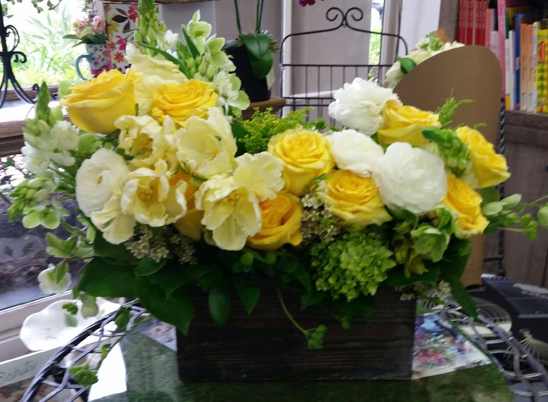 Happiness Happiness - A selection of yellow roses, white roses, hydrangea, tulips, freesia and garden greenery arranged in a wooden box.