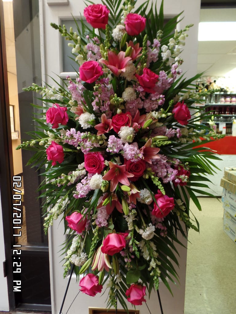 Sympathy Standing Spray - Sending thousands of words of condolences with this standing spray. From a Standard to a Premium, each spray reflects your message through and through with snapdragons, roses, lilies, stock flowers and more as the focal flowers in this impressive flower piece.  Available in many color combinations. Please give us a few general instructions. Our designers will create this flowers piece with those details and specific to select color scheme and flowers selections. Premium selection shown.