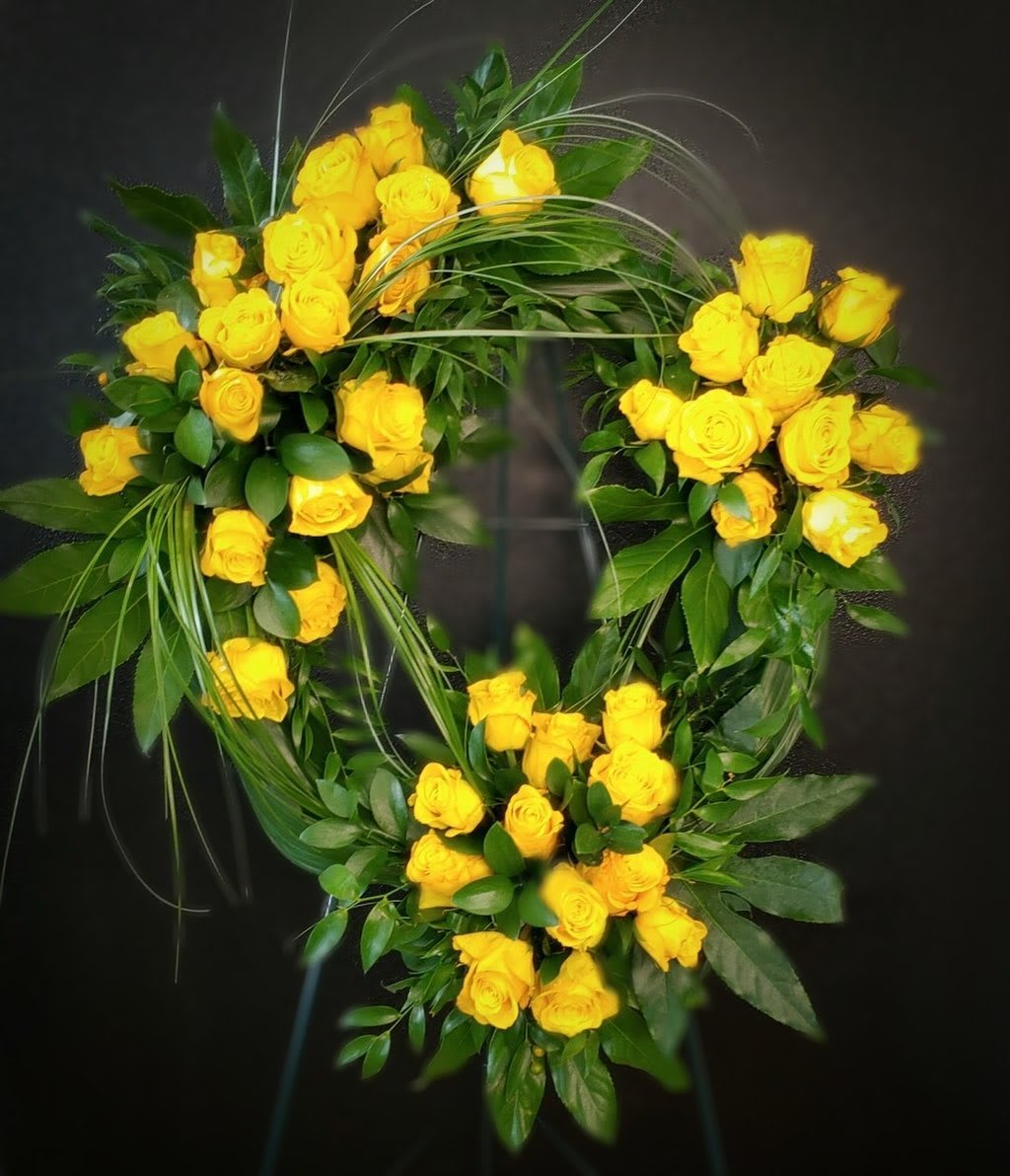 Friendship Wreath  - This standing wreath is elegantly arranged with yellow roses and greenery. It is a perfect tribute for a loved one. Other colors can be suggested in special instructions box. 