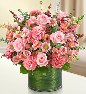Cherished Memories - All Pink - Product ID: 95385   Send a gift of lasting tribute that captures their cherished memories of loved ones who have passed on. Our color-soaked, all-pink arrangement of roses, spray roses, snapdragons, alstroemeria, carnations and more is tastefully arranged in a glass cylinder vase to offer a comforting message. Fresh arrangement of pink roses, spray roses, snapdragons, alstroemeria, carnations, asters and heather, gathered with variegated pittosporum, salal and spiral eucalyptus Hand-designed by our expert florists in a stylish clear glass cylinder vase wrapped with a Ti leaf ribbon; vase measures 6&quot;H Appropriate for the service or the home of friends and family members Large arrangement measures approximately 16&quot;H x 17&quot;L Medium arrangement measures approximately 15&quot;H x 16&quot;L Small arrangement measures approximately 14&quot;H X 15&quot;L Our florists hand-design each arrangement, so colors, varieties, and vase may vary due to local availability