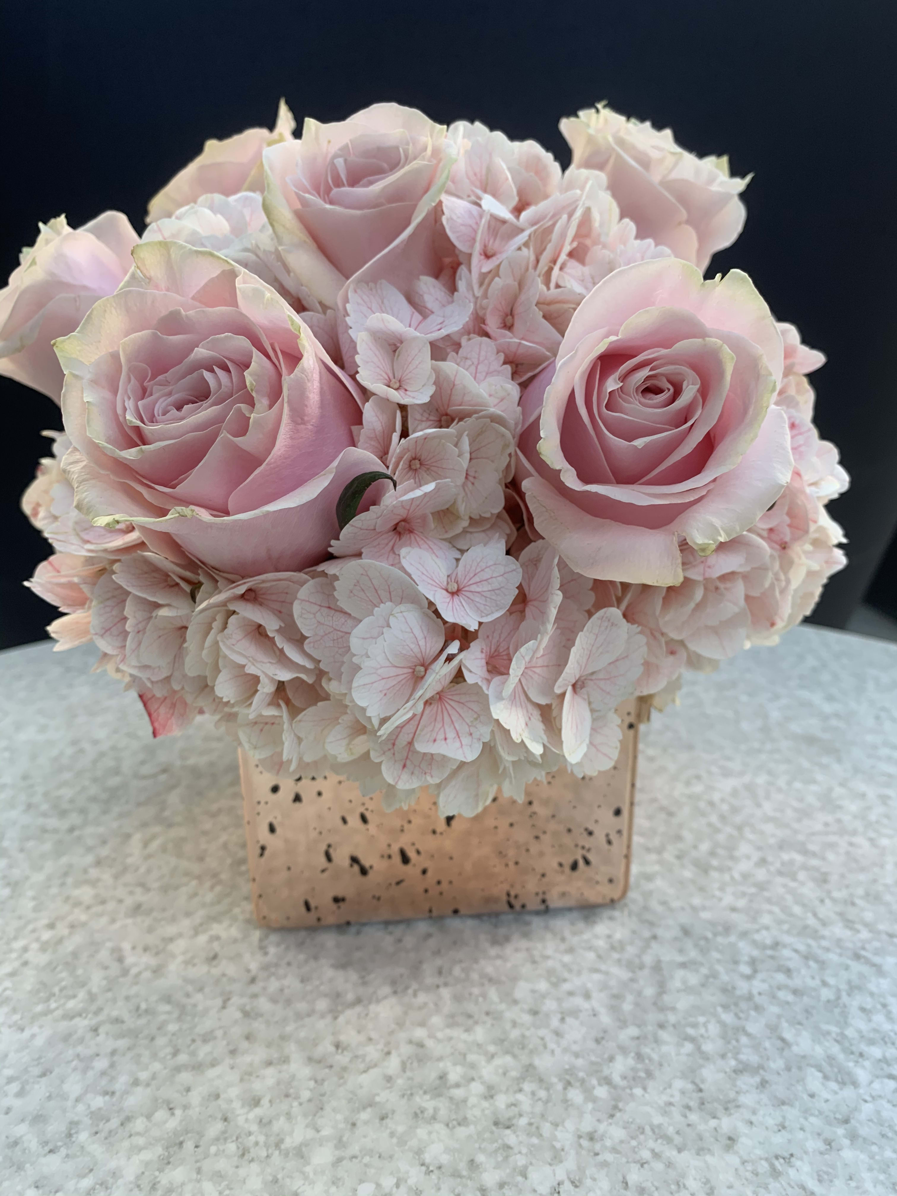 Pretty in Pink - The name says it all ! This is for that special someone who needs pink in their life.  This is a very sweet design featuring six of our gorgeous pink roses, hydrangea's and  subtle green accents. Upgrade to add and even fuller effect. upgrade for a bigger container more flowers.  