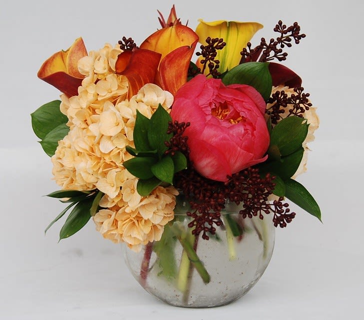Tujunga CA Flowers - A glass round bowl filled with orange, yellow calla lilies, coral peonies, and hydrangea, accented with greenery and seeded eucalyptus.